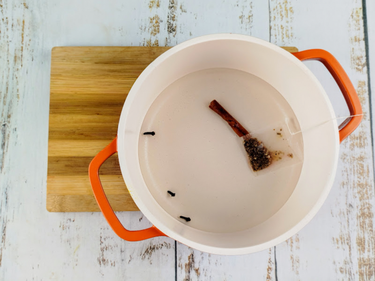 Panela com água, canela, cravo e sachê de chá.