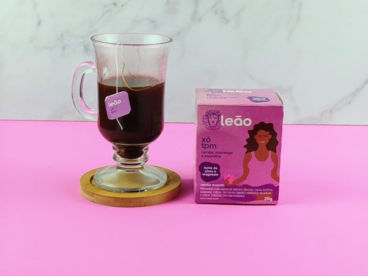 Sachê de chá em infusão em uma xícara de vidro.