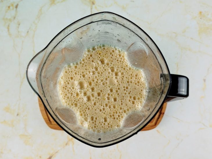 Liquidificador com a polpa de maracujá batida com chá e gelo.