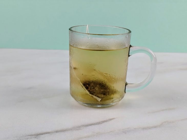 Chá infusionando numa caneca com água.