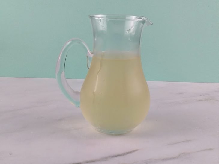 Chá, água de coco e suco misturados em uma jarra.