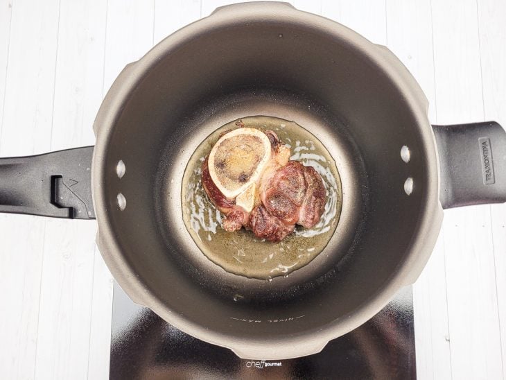 Uma panela com azeite e ossobuco.