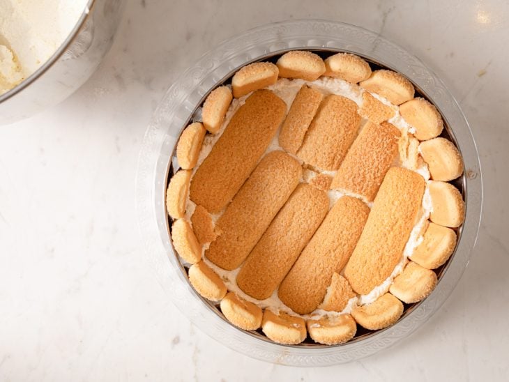 Uma forma com bolachas champagne e creme de chantilly.