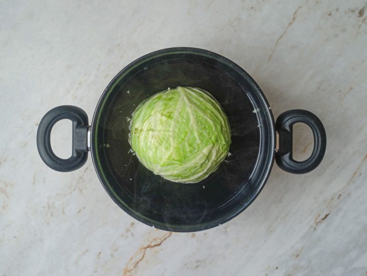 Repolho sendo cozido em água fervente dentro de uma panela grande.