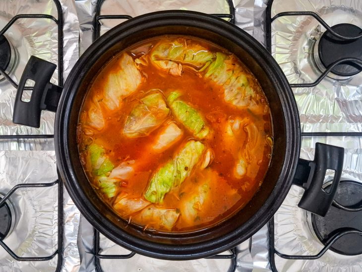 Charutos de repolho cozinhando no molho.