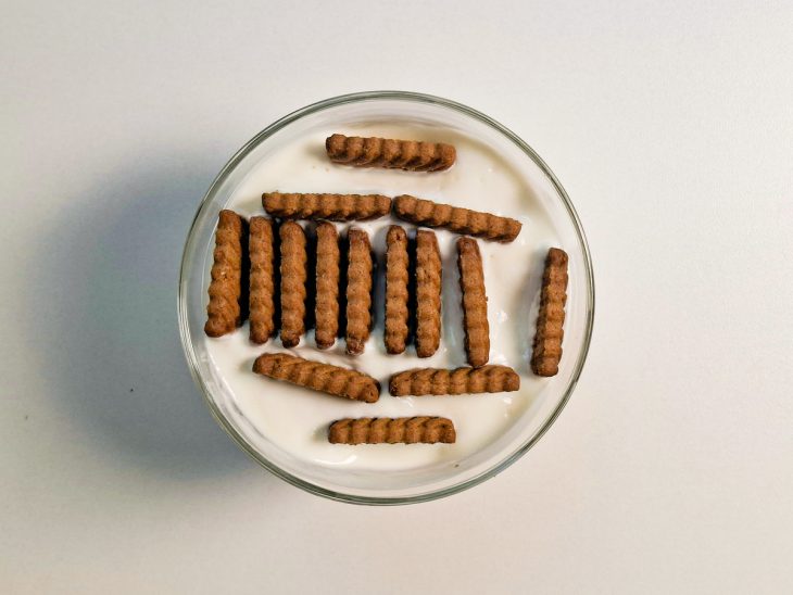 Biscoitos dispostos verticalmente dentro do iogurte formando camadas.