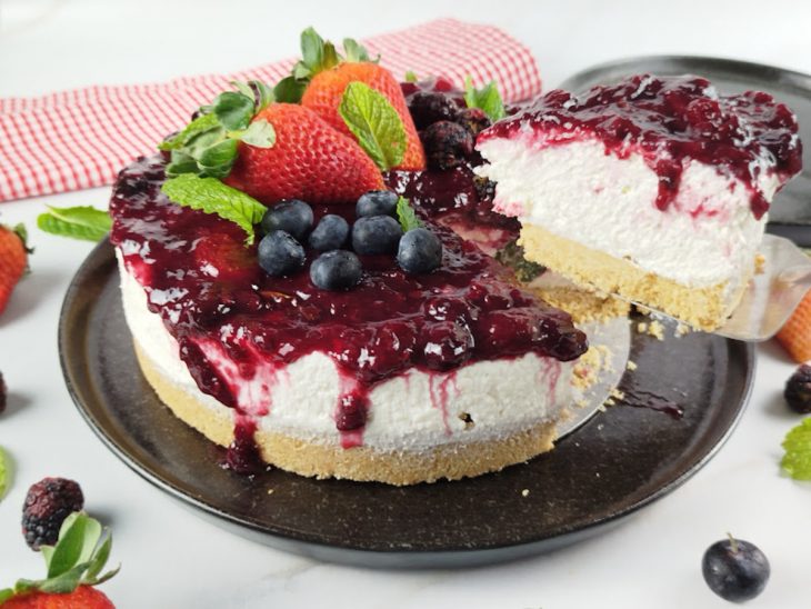 Fatia de cheesecake sendo retirada de sua totalidade.