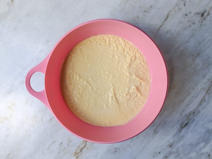 Mistura cremosa de milho transferida para um recipiente.