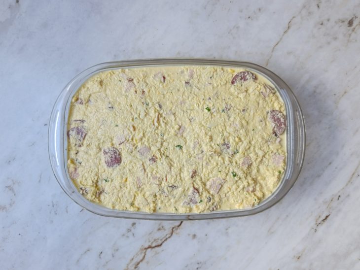 Massa distribuída em assadeira e superfície nivelada.