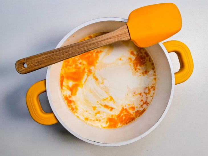 Em outra panela, o leite, o leite condensado, o creme de leite, as gemas e a essência de baunilha.