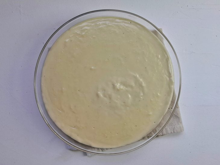 Bananas caramelizadas em uma travessa de vidro cobertas por creme