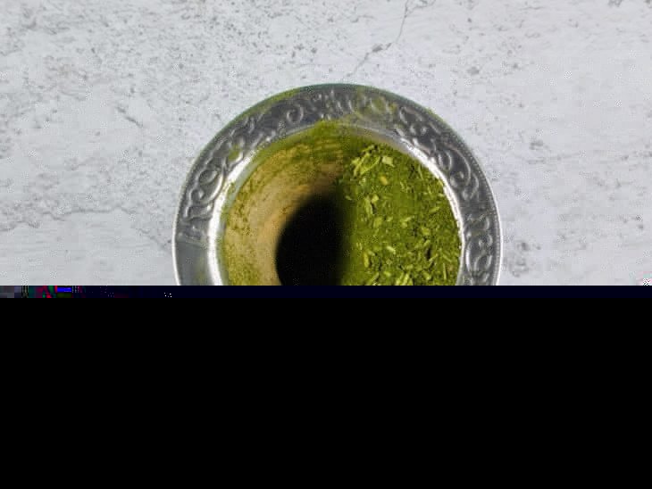 Cuia com o pó da erva de um lado.
