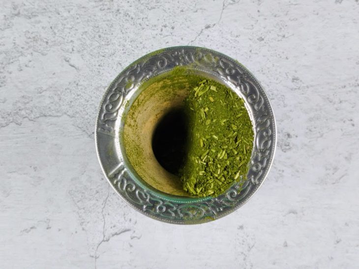 Cuia em sua posição normal, com a erva de chimarrão apenas em um dos lados do lado de dentro.