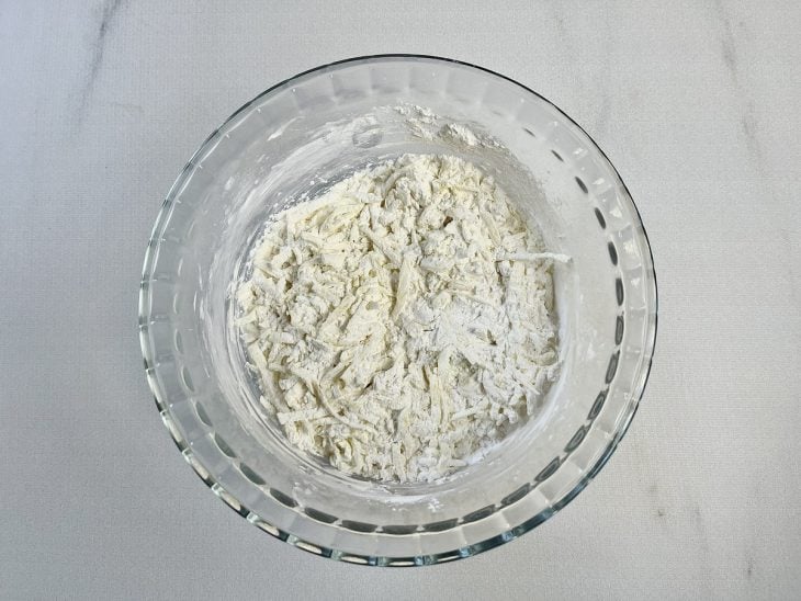 Ingredientes misturados em uma tigela de vidro redonda.