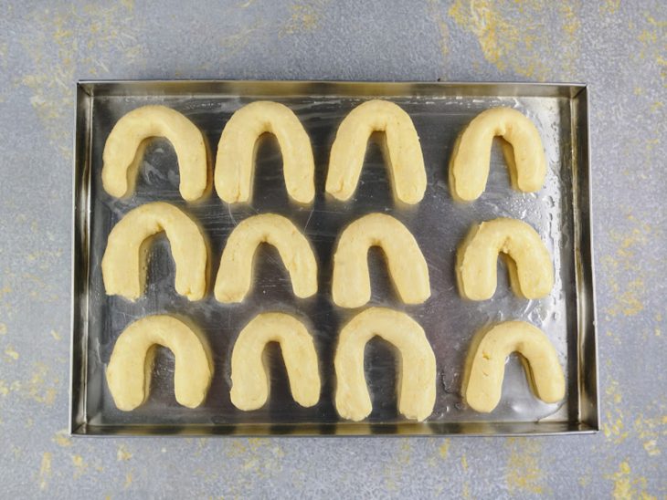 Massa de chipa moldadas e dispostas sobre a assadeira.