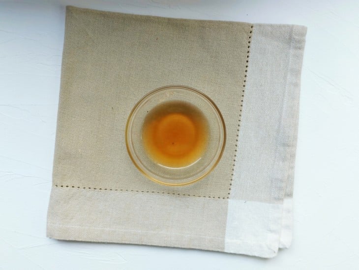Um recipiente com a mistura de água, extrato de baunilha e suco de limão.