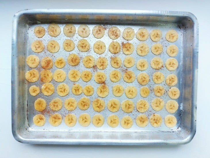 Uma forma com rodelas de banana polvilhada com canela em pó.
