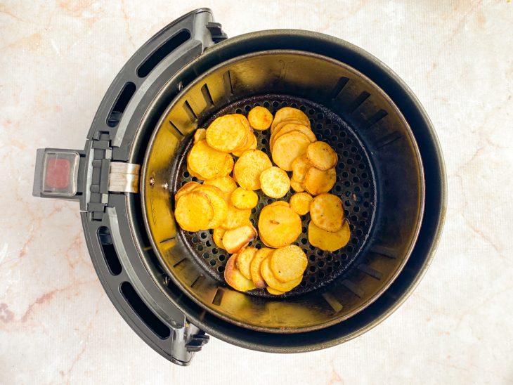 Após os primeiros 5 minutos, air fryer aberta para mexer os chips já dourados.