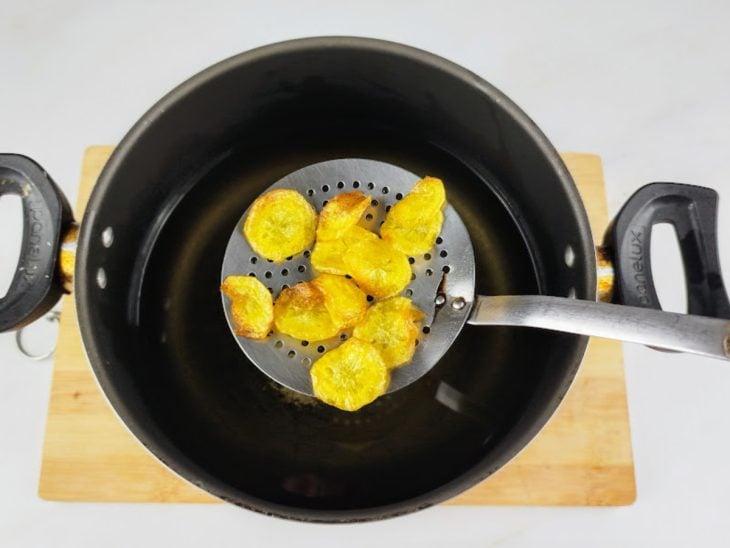 Rodelas fritas em uma escumadeira.