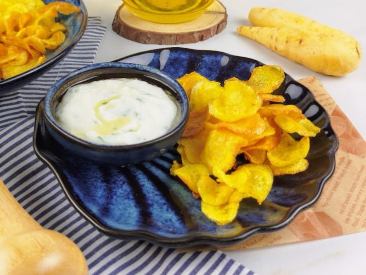 Chips de mandioquinha acompanhado por molho e pronto para servir.