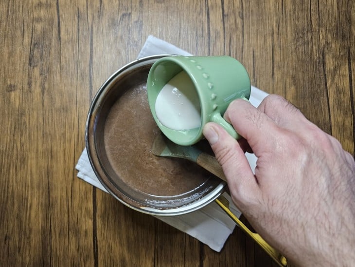 Creme de leite sendo adicionado à mistura da panela.