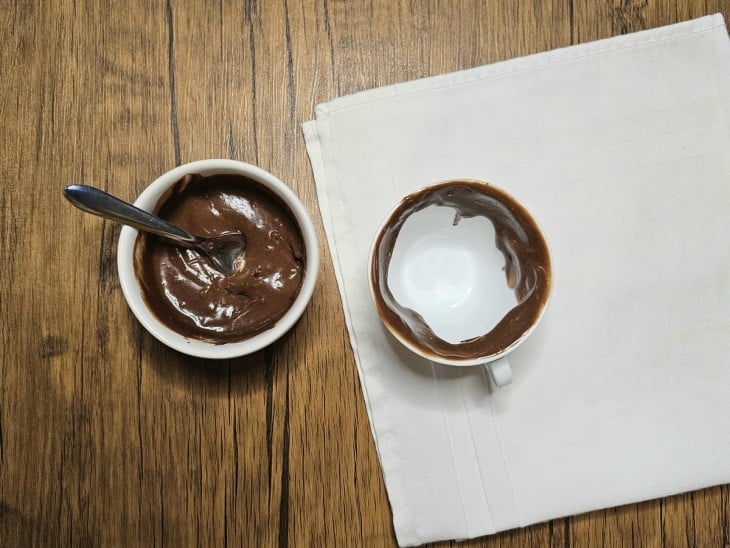 Recipiente com ganache e xícara decorada com um pouco de ganache.