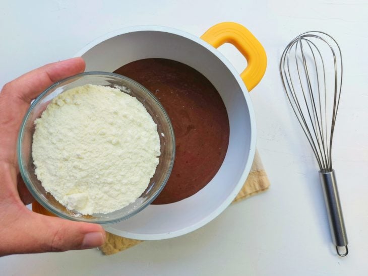 Uma panela contendo a mistura de creme de leite, chocolate em pó e leite em pó.