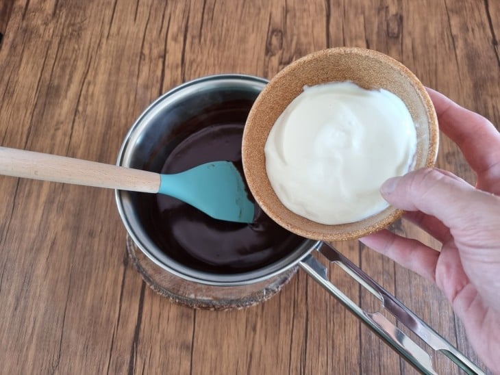 Creme de leite sendo adicionado na mistura do chocolate quente.