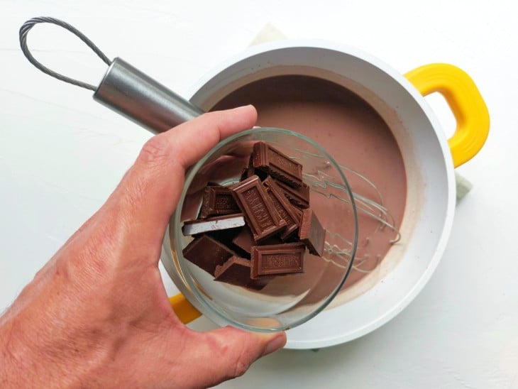 Chocolate em barras sendo adicionado na panela.