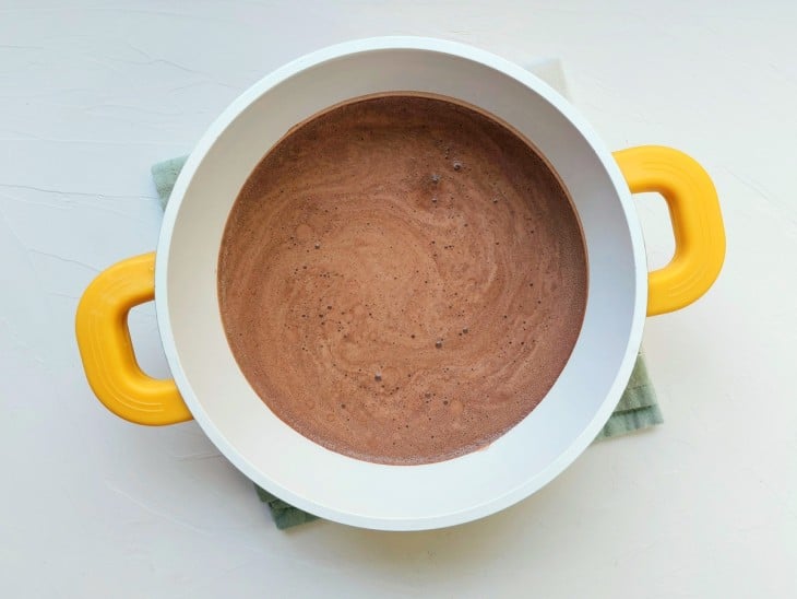 Uma panela com a mistura de leite e chocolate em pó.