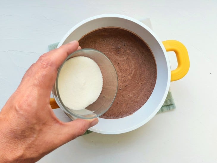 Uma panela com a mistura de leite, açúcar e chocolate em pó.