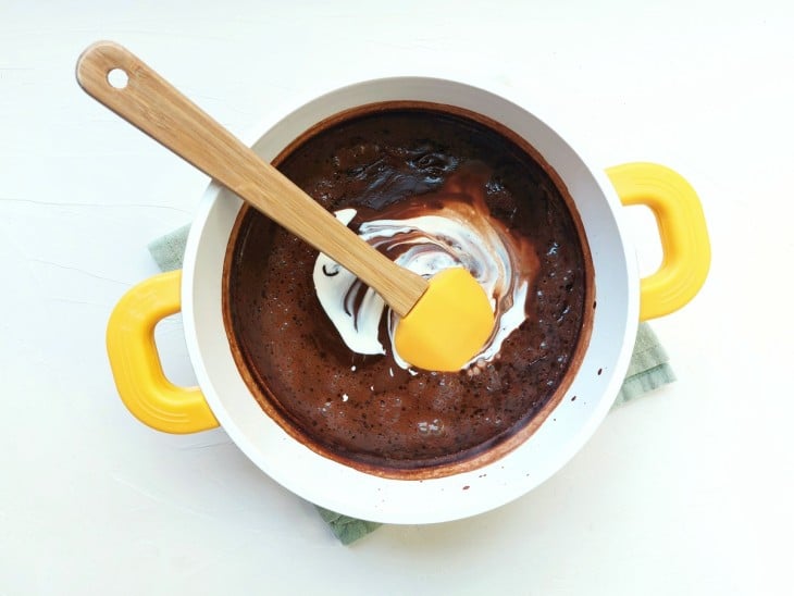 Uma panela com a mistura de chocolate quente e creme de leite.