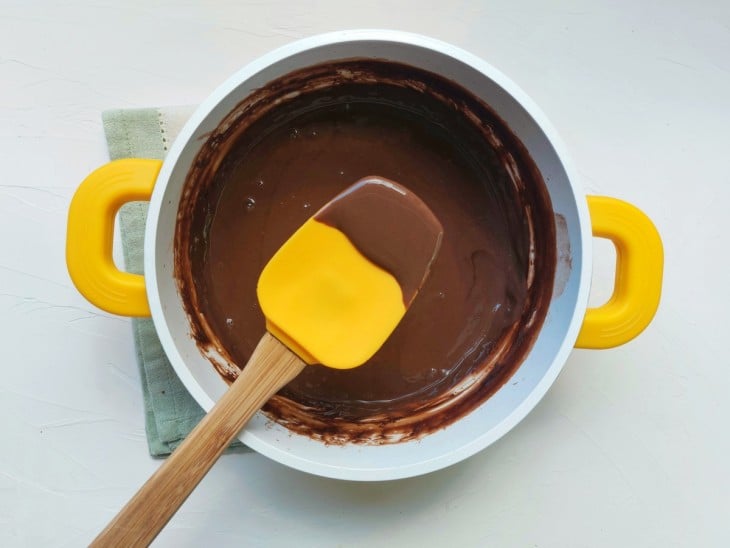 Uma panela com o chocolate quente cremoso.