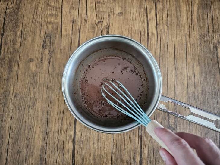 Uma panela com a mistura dos leites com cacau em pó.