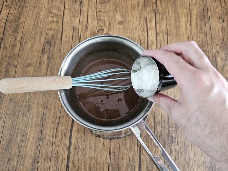 Uma panela com a mistura dos leites com cacau em pó e açúcar.