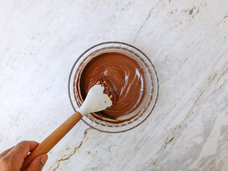 Numa tigela, o chocolate derretido no micro-ondas.