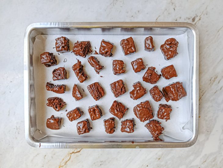 Pedaços de chocotone coberto com chocolate distribuídos numa forma.