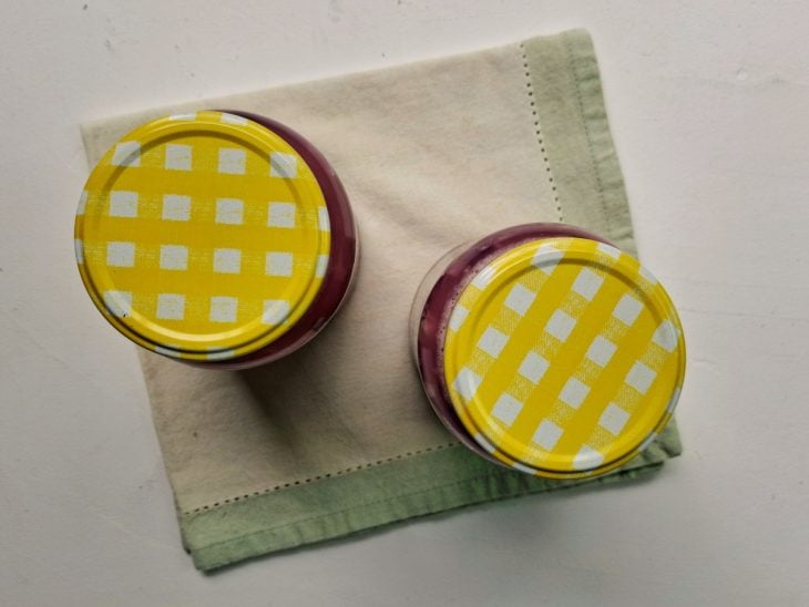 Dois potes fechados contendo chucrute de repolho roxo.