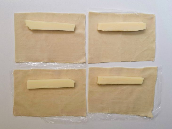 Queijo sendo colocado sobre a massa.