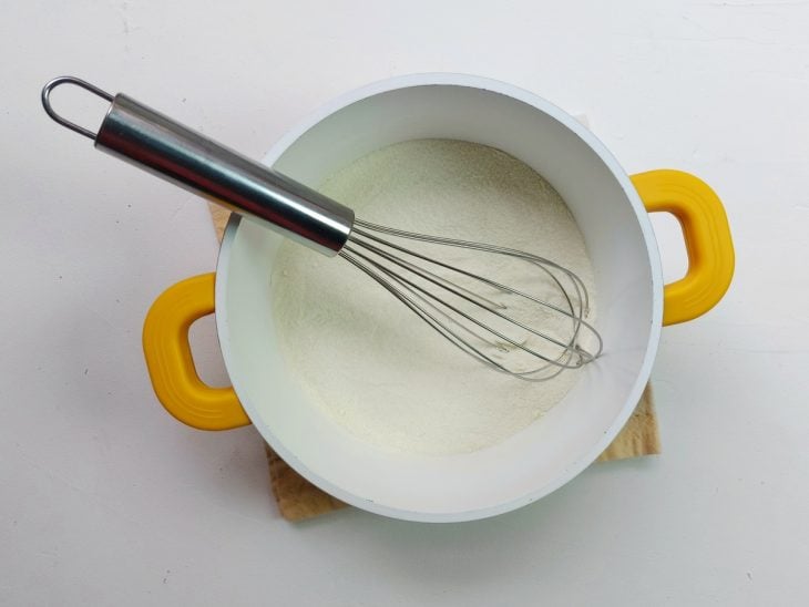 Uma panela contendo a mistura de açúcar, farinha e leite em pó.