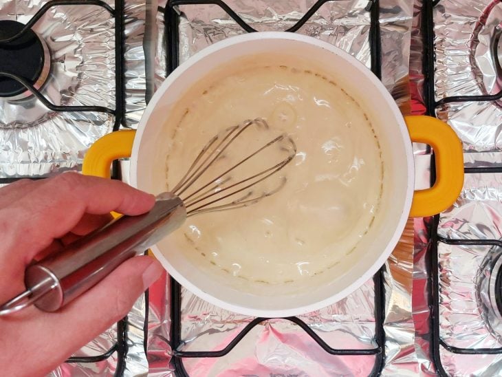 Uma panela cozinhando creme branco.