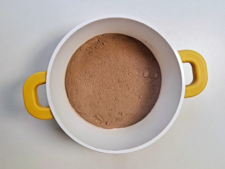 Açúcar e chocolate em pó misturados em uma panela.