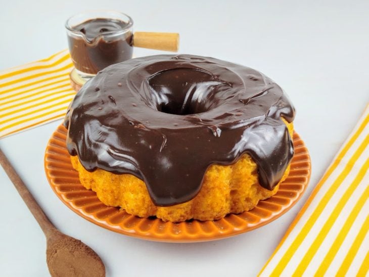 Bolo de cenoura coberto com a cobertura de chocolate cremosa.