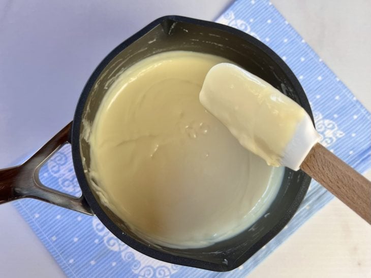 Uma panela contendo brigadeiro branco de leite Ninho.