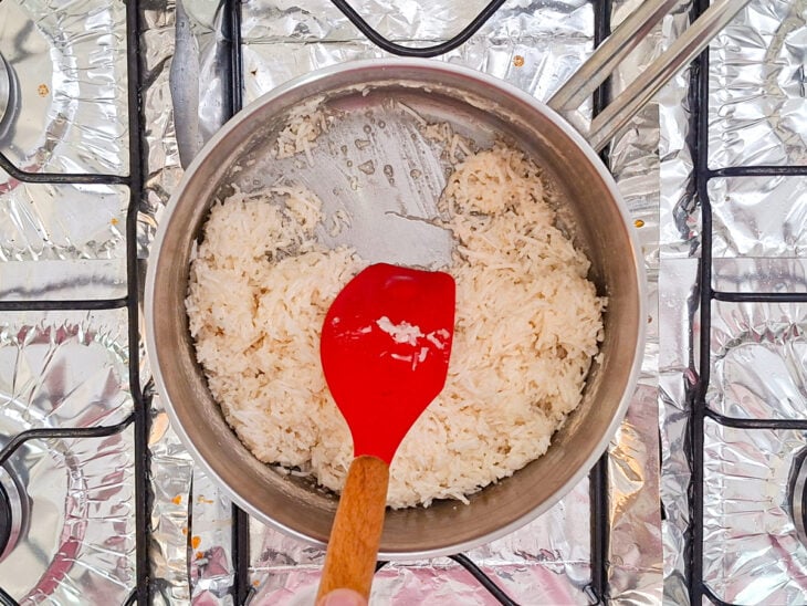 Mistura de coco e calda sendo cozida até começar a soltar do fundo da panela.