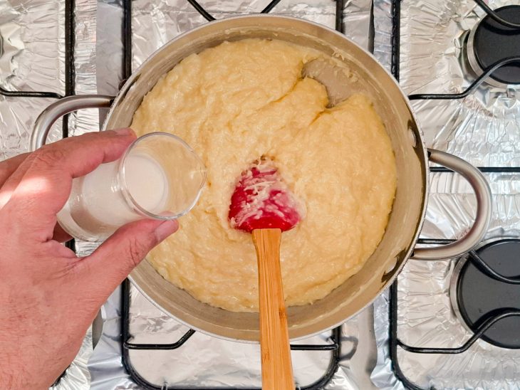 Leite sendo adicionado a mistura da panela.