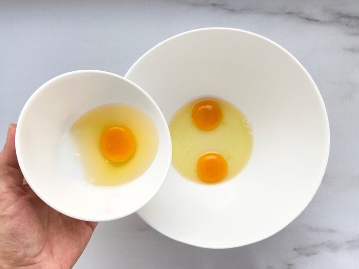 Dois recipientes contendo ovos quebrados.