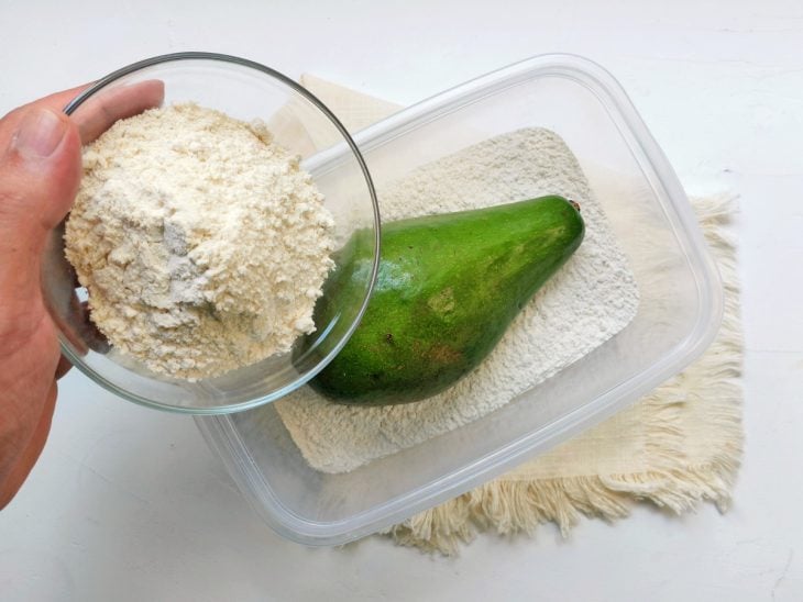 Um recipiente contendo um abacate e farinha.