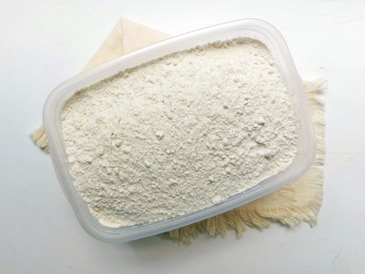 Um recipiente contendo um abacate e farinha.