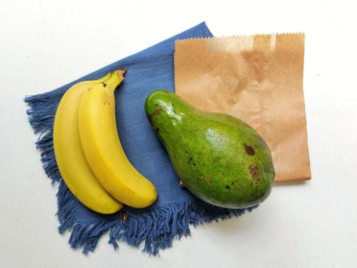 Uma bancada contendo um abacate e duas bananas.